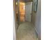Hallway featuring carpeted floors and a doorway leading to the main bathroom at 4612 Club Dr # D102, Port Charlotte, FL 33953