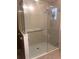 Glass-enclosed shower with tiled walls and safety grab bar, providing a clean and modern look at 4612 Club Dr # D102, Port Charlotte, FL 33953