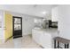 Bright kitchen featuring white cabinetry, granite countertops, stainless steel appliances, and yellow-painted front door at 5041 N Beach Rd # 2A And 2B, Englewood, FL 34223