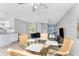 Bright living room features tile floors, a glass dining table with wicker chairs, and slider doors to the lanai at 5041 N Beach Rd # 2A And 2B, Englewood, FL 34223