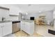 Open-concept living area featuring granite countertops, stainless steel appliances, and a wicker dining table at 5041 N Beach Rd # 2A And 2B, Englewood, FL 34223
