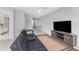 This living room showcases tile floors, a modern TV, a comfortable black couch, and slider doors to the lanai at 5041 N Beach Rd # 2A And 2B, Englewood, FL 34223