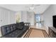The open living room offers tile floors, a black couch, modern furniture, and slider doors to a screened lanai at 5041 N Beach Rd # 2A And 2B, Englewood, FL 34223