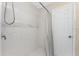 Bright shower with white tile and an overhead shower head and door at 5041 N Beach Rd # 2A And 2B, Englewood, FL 34223