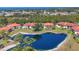 Aerial view of condos with a blue pond, lush trees, and neighborhood at 507 Pine Hollow Cir # 507, Englewood, FL 34223