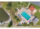 Aerial view of community pool with surrounding blue lounge chairs and bathroom building at 507 Pine Hollow Cir # 507, Englewood, FL 34223