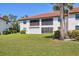 Exterior of the back of the property with sliding glass doors and a spacious lawn at 507 Pine Hollow Cir # 507, Englewood, FL 34223