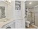 Bathroom with a vanity, granite countertop, large mirror, cabinets, shelving, and a toilet and shower at 507 Pine Hollow Cir # 507, Englewood, FL 34223