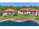 Beautiful condo building with red tile roof and lush landscaping with a lake view at 507 Pine Hollow Cir # 507, Englewood, FL 34223
