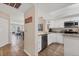 Bright kitchen with stainless steel appliances, granite countertops, and white cabinetry and views into living room at 507 Pine Hollow Cir # 507, Englewood, FL 34223