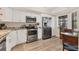 Well-lit kitchen featuring stainless steel appliances, granite countertops and light wooden floors at 507 Pine Hollow Cir # 507, Englewood, FL 34223