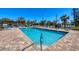 Community pool with brick pavers, blue lounge chairs and pergola at 507 Pine Hollow Cir # 507, Englewood, FL 34223