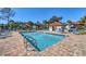 Community pool with brick pavers, blue lounge chairs, pergola, and bathroom at 507 Pine Hollow Cir # 507, Englewood, FL 34223
