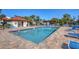 Community pool with brick pavers, blue lounge chairs, pergola, and bathroom at 507 Pine Hollow Cir # 507, Englewood, FL 34223