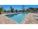 Community pool with brick pavers and blue lounge chairs, great for relaxation at 507 Pine Hollow Cir # 507, Englewood, FL 34223