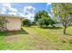 View of the home's side yard with mature trees and well-maintained lawn at 6206 Marcum St, Englewood, FL 34224