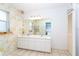 Bathroom featuring double sinks, a large mirror, and decorative floral wallpaper at 6206 Marcum St, Englewood, FL 34224