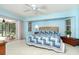 Bright bedroom with light blue walls, ceiling fan and sliding door leading to backyard at 6206 Marcum St, Englewood, FL 34224