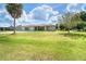 The well-maintained ranch-style home has a three-car garage, lush green lawn, and sunny skies at 6206 Marcum St, Englewood, FL 34224