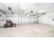Three car garage with ample storage and a lawn mower at 6206 Marcum St, Englewood, FL 34224
