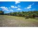 A canal view from a grassy backyard with a small boat docked on the waters edge at 6417 Klaus Ct, Port Charlotte, FL 33981