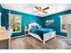 Bright bedroom with blue walls and luxury vinyl plank flooring, as well as a white bed at 6417 Klaus Ct, Port Charlotte, FL 33981