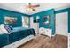 This is a brightly lit bedroom featuring blue walls, and white dressers with decorative mirror at 6417 Klaus Ct, Port Charlotte, FL 33981