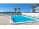 The community pool is surrounded by plenty of seating and mature palm trees at 6417 Klaus Ct, Port Charlotte, FL 33981