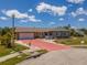 Well-maintained home featuring stone accents, a red driveway, and inviting curb appeal at 6417 Klaus Ct, Port Charlotte, FL 33981