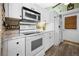 Kitchen with stainless appliances, white cabinetry and luxury vinyl plank flooring at 6417 Klaus Ct, Port Charlotte, FL 33981