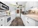 Bright kitchen with white cabinetry, stainless steel appliances, brick backsplash, and wood-look flooring at 6417 Klaus Ct, Port Charlotte, FL 33981