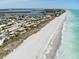 Breathtaking aerial view of a pristine sandy beach meeting the turquoise ocean, highlighting the coastal charm at 7234 Mamouth St, Englewood, FL 34224