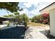 Lush backyard showing well-manicured landscaping, palm trees, and privacy shrubs near the screened-in pool at 7234 Mamouth St, Englewood, FL 34224
