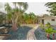 Landscaped backyard with stepping stone pathway and plenty of mature trees and greenery offering a serene outdoor space at 7234 Mamouth St, Englewood, FL 34224