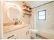 Bathroom boasts a modern vanity with granite countertop, decorative shelving, and marble tiled shower at 7234 Mamouth St, Englewood, FL 34224