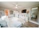 Spacious primary bedroom features a walk-in closet, tv, and warm, inviting décor at 7234 Mamouth St, Englewood, FL 34224