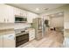 Well-lit kitchen featuring stainless steel appliances, granite countertops, and white cabinetry at 7234 Mamouth St, Englewood, FL 34224