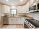 Modern kitchen with white cabinets, granite countertops, and stainless steel appliances at 7234 Mamouth St, Englewood, FL 34224