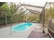 Outdoor pool with screened-in enclosure features comfortable lounge seating and ambient string lights at 7234 Mamouth St, Englewood, FL 34224