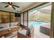 Sunroom with indoor pool access with comfortable seating and a mounted TV, perfect for relaxing at 7234 Mamouth St, Englewood, FL 34224