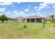Spacious backyard featuring a storage shed, lush green grass, and the back of the house with screened in lanai at 7393 Mamouth St, Englewood, FL 34224