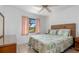 Cozy bedroom featuring a window with curtains, a comfortable bed, and natural lighting at 7393 Mamouth St, Englewood, FL 34224