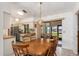 Well-lit dining area with a wooden table, tile floors, and access to the kitchen at 7393 Mamouth St, Englewood, FL 34224