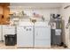 Functional laundry room with washer, dryer, water heater and storage shelves, providing ample space at 7393 Mamouth St, Englewood, FL 34224