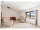 Spacious living room with tile floors, featuring a ceiling fan, desk and two comfortable recliners at 7393 Mamouth St, Englewood, FL 34224