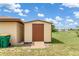 Close up of a storage shed with a ramp and double door entry, nestled in a green backyard at 7393 Mamouth St, Englewood, FL 34224