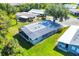 Aerial view of a well-maintained home with a metal roof, screened-in lanai and lush landscaping at 878 Fawnspring Ct, Englewood, FL 34223
