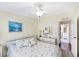 Bedroom featuring a ceiling fan, and a mirrored closet door, with a view to the ensuite bathroom at 878 Fawnspring Ct, Englewood, FL 34223