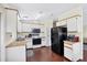 Well-lit kitchen featuring white cabinets and black appliances with wood look countertops at 878 Fawnspring Ct, Englewood, FL 34223
