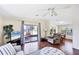 Bright living room featuring a ceiling fan, hardwood floors, and sliding glass doors to the lanai at 878 Fawnspring Ct, Englewood, FL 34223